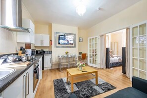 A compact living space with a kitchenette, dining area, and a bedroom with a large window. - *VA1* For your Relaxed & Cosy stay + Free Parking (Osmondthorpe)