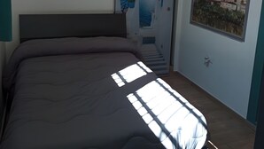 A bedroom with a bed, a window with a view of a mountain, and a door with a glass panel. - De Luxe Apartment just 150 m from the Sea in Central Giulianova (Giulianova)