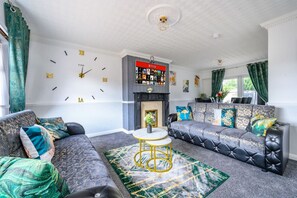 A living room with a fireplace, a sofa set, a coffee table, and a wall clock. - *328OL* For your relaxed & Cosy stay + Parking (West Yorkshire)