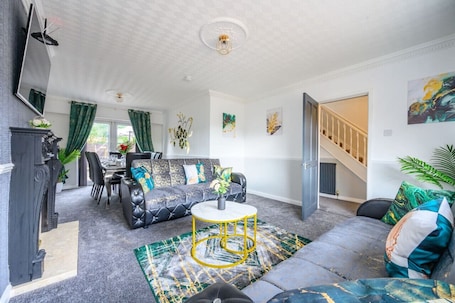 A living room with a sofa, a coffee table, a fireplace, and a staircase leading to another level.. *328OL* For your relaxed & Cosy stay + Parking