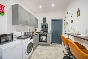 A compact kitchen with a washing machine, a microwave, and a stove. - *F19GH* For relaxed & Cosy stay/Free Parking/WiFi (West Yorkshire)