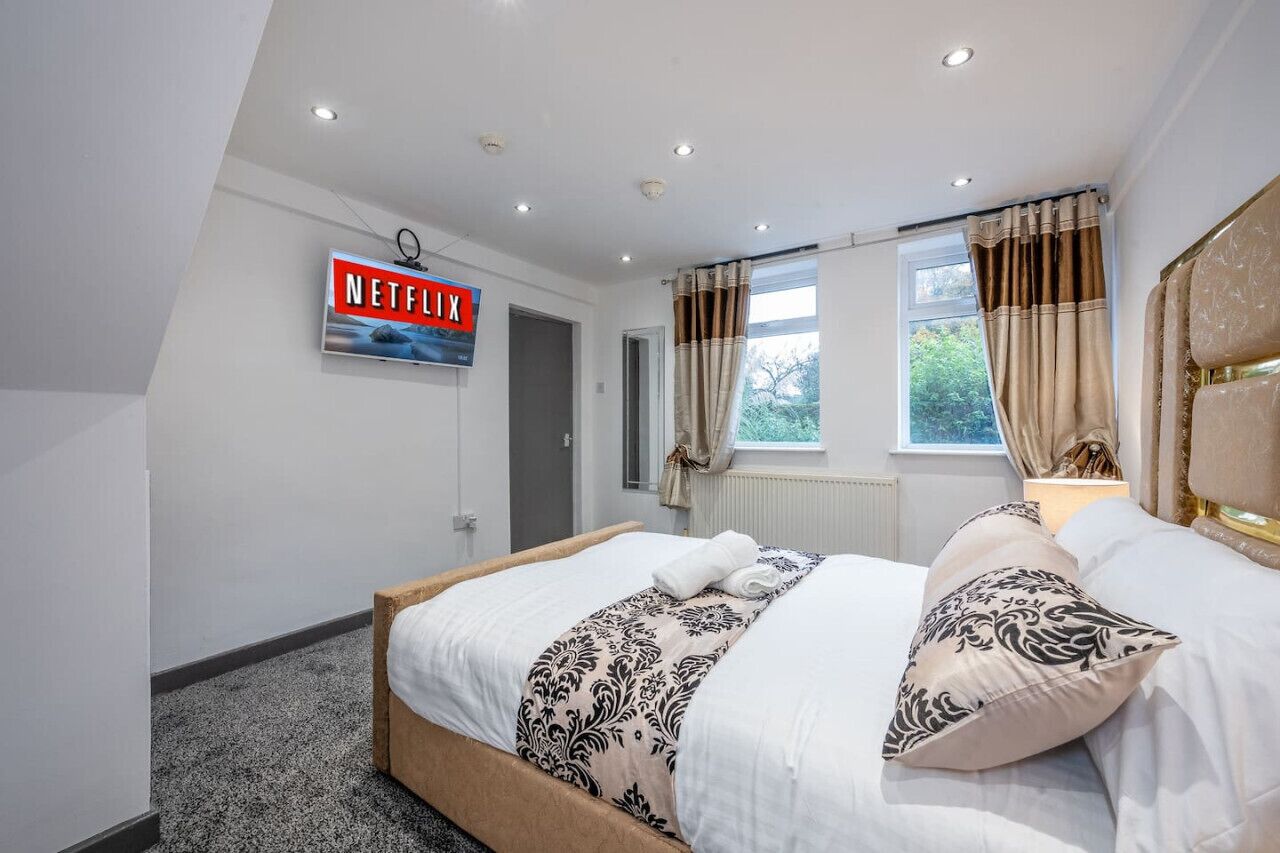 A bedroom with a bed, a window with curtains, a door, and a sign on the wall.. *F4GH for your most relaxed & Cosy stay + Parking