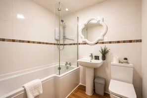 Ein Badezimmer mit Duschkabine, Waschbecken und WC.
