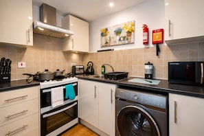 A modern kitchen with a stove, oven, microwave, and washing machine. - *F2GH* for your most relaxed & Cosy stay +Parking (West Yorkshire)
