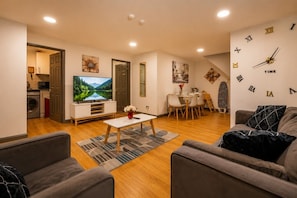 A modern living room with a flat-screen TV, a dining area with chairs, a sofa, and a wall clock. - *F2GH* for your most relaxed & Cosy stay +Parking (West Yorkshire)