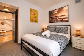 A neatly made bed with a patterned bedspread, a bedside lamp, and a painting above the bed. - *F2GH* for your most relaxed & Cosy stay +Parking (West Yorkshire)