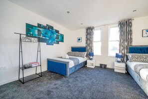 A bedroom with two beds, a standing shelf, a desk, and a window with curtains. - *372kr* For your relaxed & Cosy stay + Parking (Burley)