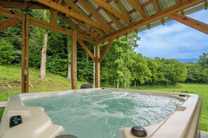 A hot tub under a wooden pergola with a natural landscape in the background. - 🌄 The Farmhouse at Foothills Farm 🌲 1930s Farmhouse, Creek & Hot Tub (Cosby)