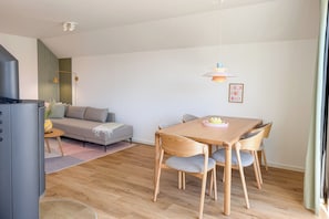 A modern living space with a dining area, sofa, and a television. - Tower of Power – Balcony, Fireplace, Upper Floor, Washing Machine, Private Parki (Olpenitz)