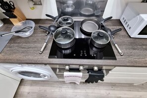 A kitchen with a built-in stove, pots, pans, a microwave, and a washing machine. - *6R*your most amazing & relaxed stay + Free Parking + Free Fast WiFi * (Holbeck)