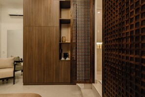 Un interior moderno con un armario de madera, un separador decorativo y una zona de estar.
