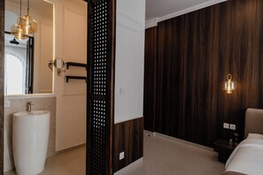 A modern bathroom with a large sink, mirror, and wooden panel wall. - Riviera Boutique Hotel (Ubud)