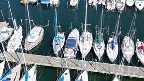 Een jachthaven met meerdere boten die achter elkaar liggen aangemeerd.