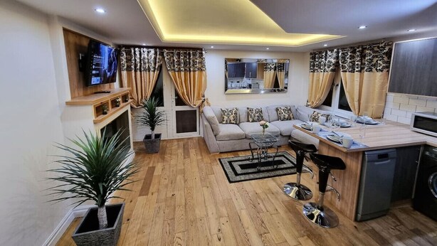 Una cocina moderna con comedor, piso de madera y televisor integrado.