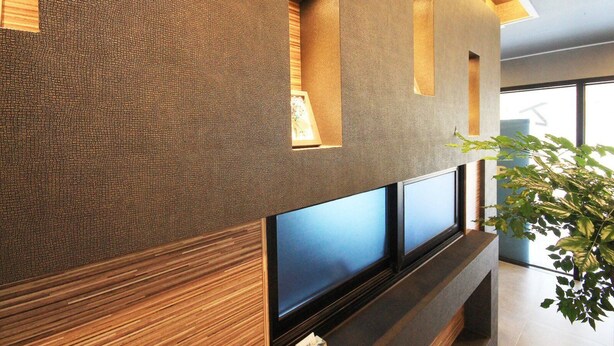 Un interior moderno con pared texturizada, iluminación empotrada y ventanas amplias.