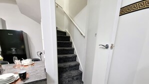 A narrow hallway with a carpeted staircase leading to a room. - *11BR* Setup for your most amazing relaxed stay + Free Parking + Free Fast WiFi (West Yorkshire)