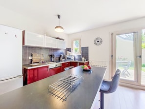 Een moderne keuken met een centraal eiland, een eethoek en uitzicht op de omgeving.
