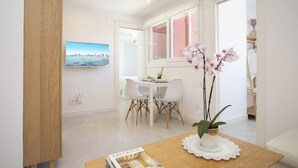 A dining area with a table, chairs, a potted plant, and a framed picture on the wall. - Immerse yourself in the ultimate summer experience in this exclusive designer retreat, created for those seeking tranquility infused with Mediterranean charm. This apartment stands out for its bright and contemporary interior design, where every detail h (La Pobla de Farnals)