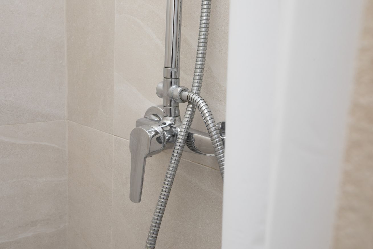 A shower with a handheld showerhead and a flexible hose.