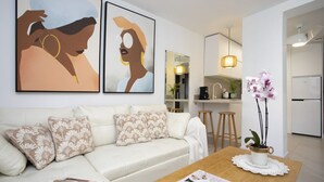 A living room with a sofa, coffee table, and artwork on the wall. - Immerse yourself in the ultimate summer experience in this exclusive designer retreat, created for those seeking tranquility infused with Mediterranean charm. This apartment stands out for its bright and contemporary interior design, where every detail h (La Pobla de Farnals)