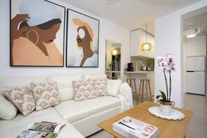 Ein Wohnzimmer mit einer Couch, einem Couchtisch und Kunstwerken an der Wand.