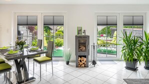 Una cocina moderna con comedor, ventanas amplias y estufa de leña.