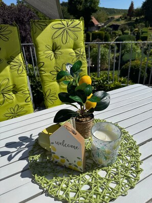 A table with a welcome card, a glass of milk, a small potted plant, and a woven placemat.