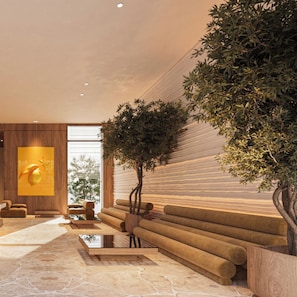 A modern interior with a large tree, a sofa, and a wooden wall. - Hotel Camelot By Artur (Ksamil)