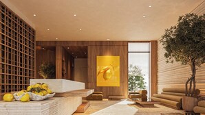Un intérieur moderne avec un sol en pierre, des meubles en bois et une grande œuvre d’art jaune.