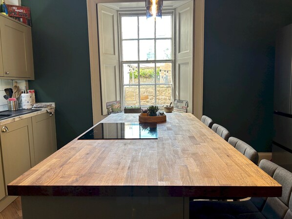 A kitchen with a large island, a window with a view, and a sign for a golf course. - Greyfriars Garden No (14A) | St Andrews (St Andrews)