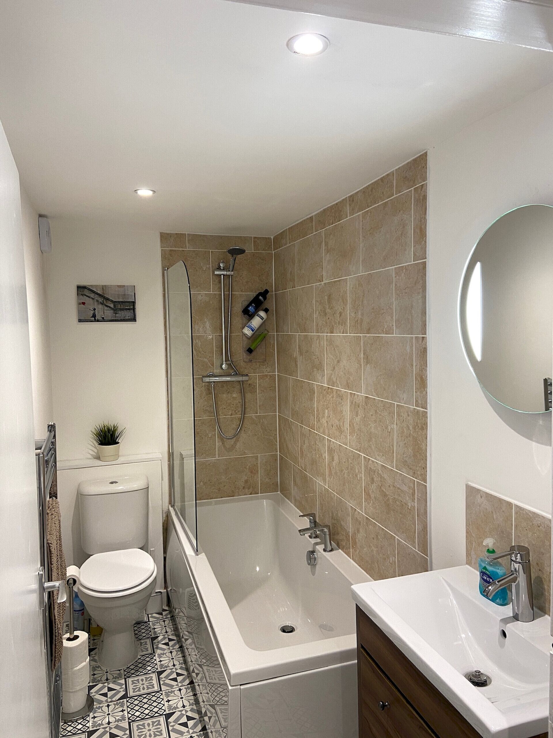 A bathroom with a toilet, bidet, bathtub, and a sink.