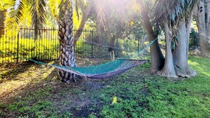 A hammock between trees in a fenced outdoor area. - Elegant Two-bedroom Apartment on the Banks of the Eerste River in Stellenbosch (Stellenbosch)