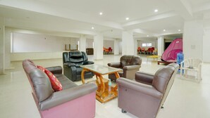 A spacious lobby with leather sofas, a glass coffee table, and a pink tent-like structure. - Classic Room With Twin Bed Hotel Looranova (Tirupati)
