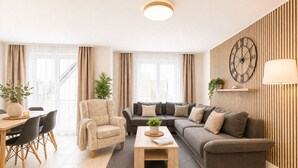Ett modernt vardagsrum med en soffa, fåtölj, soffbord och matplats.