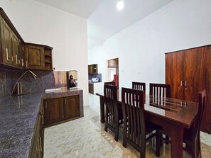 A modern kitchen with dark wooden cabinets, a granite countertop, and a built-in coffee maker.