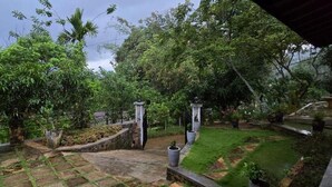 A garden with stone pathways, a fountain, and a gazebo.