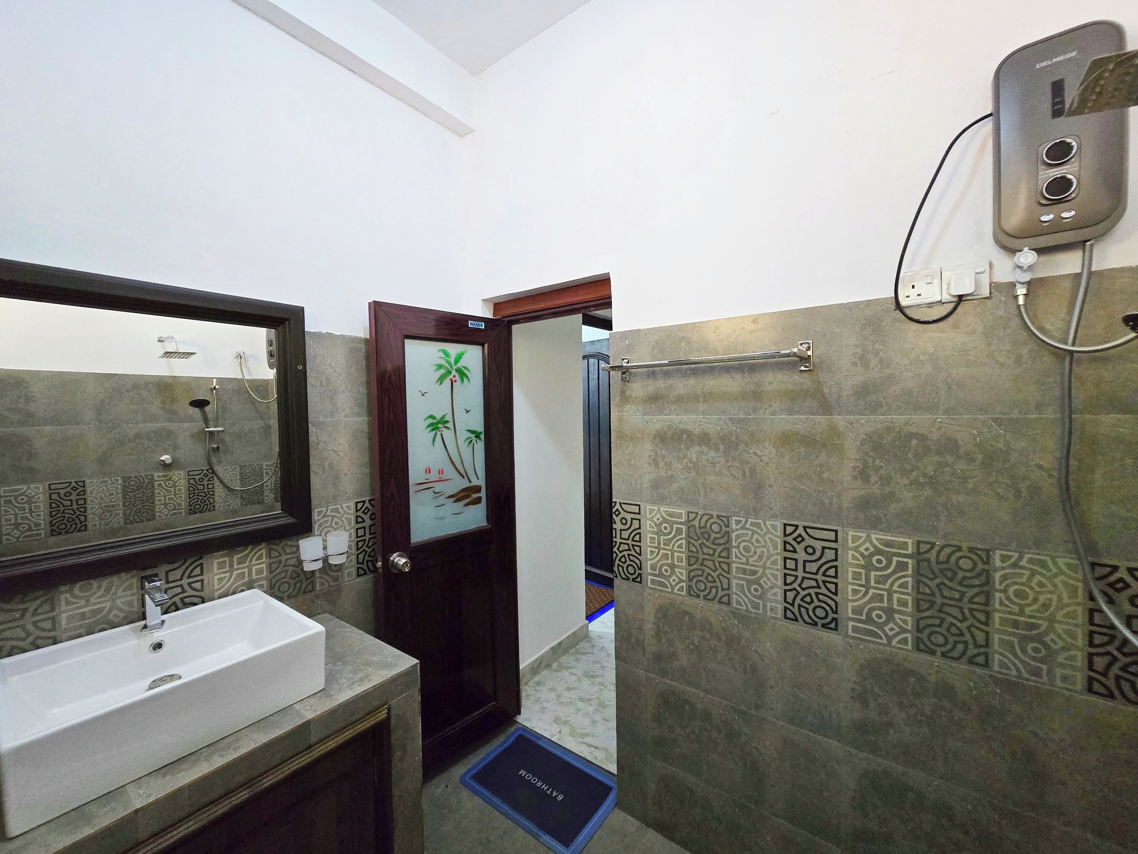 Un bagno con lavandino, specchio, doccia e porta asciugamani.