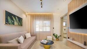 Una sala de estar moderna con un sofá, una mesa de centro, un televisor y una planta.