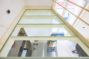 Eine Küche mit Glasdecke, Edelstahlgeräten und einem sichtbaren Fenster.
