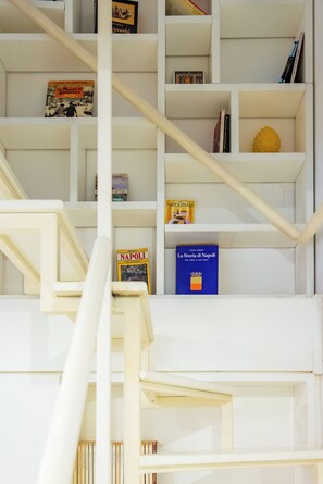 Ein mehrstöckiges Bücherregal mit verschiedenen Büchern und Dekorationselementen.