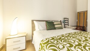 A bedroom with a bed, bedside table, lamp, and a mirror. - Vacation Home Schiavone Family (Matera)