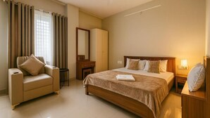 A hotel room with a bed, a sofa, a mirror, a wardrobe, and a bedside table.