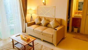A living room with a sofa, a coffee table, a lamp, and a wall-mounted light fixture.