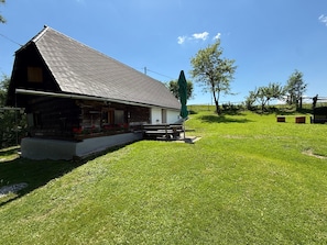 A rustic cabin with a sloped roof, a porch with a bench, and a small table. - Eselhuam – Charming Alpine Cabin Retreat on Fressenberg (Wasserleith)