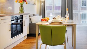Una cocina moderna con comedor, una silla verde y una mesa puesta para comer.