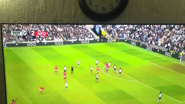 Una pantalla de televisión mostrando un partido de fútbol con un marcador que indica un resultado de 0-2.