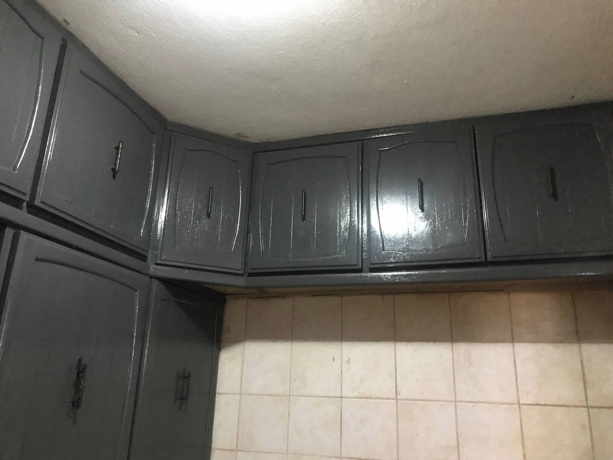 Una cocina con armarios oscuros y salpicadero de azulejos.