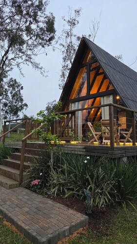 A retreat at Chalé A-Frame Parobé, with a lake, fire pit, and grill.