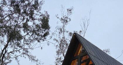 A retreat at Chalé A-Frame Parobé, with a lake, fire pit, and grill.