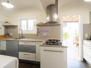 A kitchen with a gas stove, a sink, and a window. - House with sea view, pets allowed - 8 guests (Llançà)